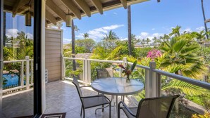 A covered outdoor area with a round table and chairs, a view of a swimming pool, and lush tropical vegetation. - Traveler Favorite! Spacious, comfortable, updated 5-STAR Wailea Retreat. 🏝  (Wailea)