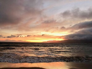 A beach with waves at sunset.