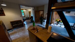 A kitchen with a wooden countertop, a stove, and a dining area with a table and chairs.