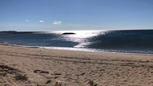 A beach with a clear sky, calm sea, and a distant island. - Exclusive Vila with private pool, wifi and air condition (Cambrils)