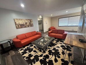 A modern living room with a sofa set, a coffee table, and a patterned rug.