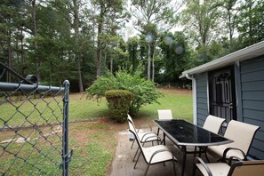Enjoy dining or socializing in this patio area with a table and chairs.