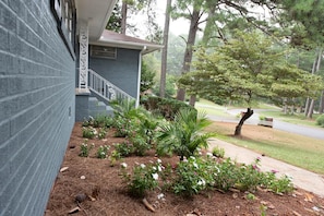 Stroll through the serene front yard, surrounded by lush plants and a majestic palm tree, and enter a charming brick home with a welcoming front door.