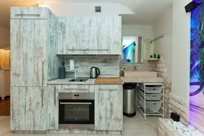 Una cocina moderna con horno empotrado, un lavamanos y una cafetera.