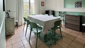 Un espace repas comprenant une table, des chaises, un téléviseur et une commode.