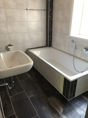 A bathroom with a bathtub, a sink, and a toilet.