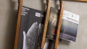 Eine Wand mit Zeitschriften und einem Staffelei aus Holz.