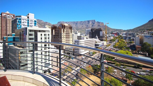 A cityscape with modern buildings, a prominent mountain in the background, and a busy street with vehicles. - Pristine Apartment in the Heart of Cape Town (Cape Town)
