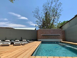 Una piscina al aire libre, tumbonas