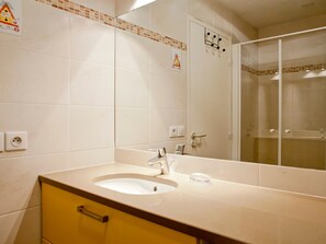 Ein Badezimmer mit Waschbecken, Spiegel und Dusche.