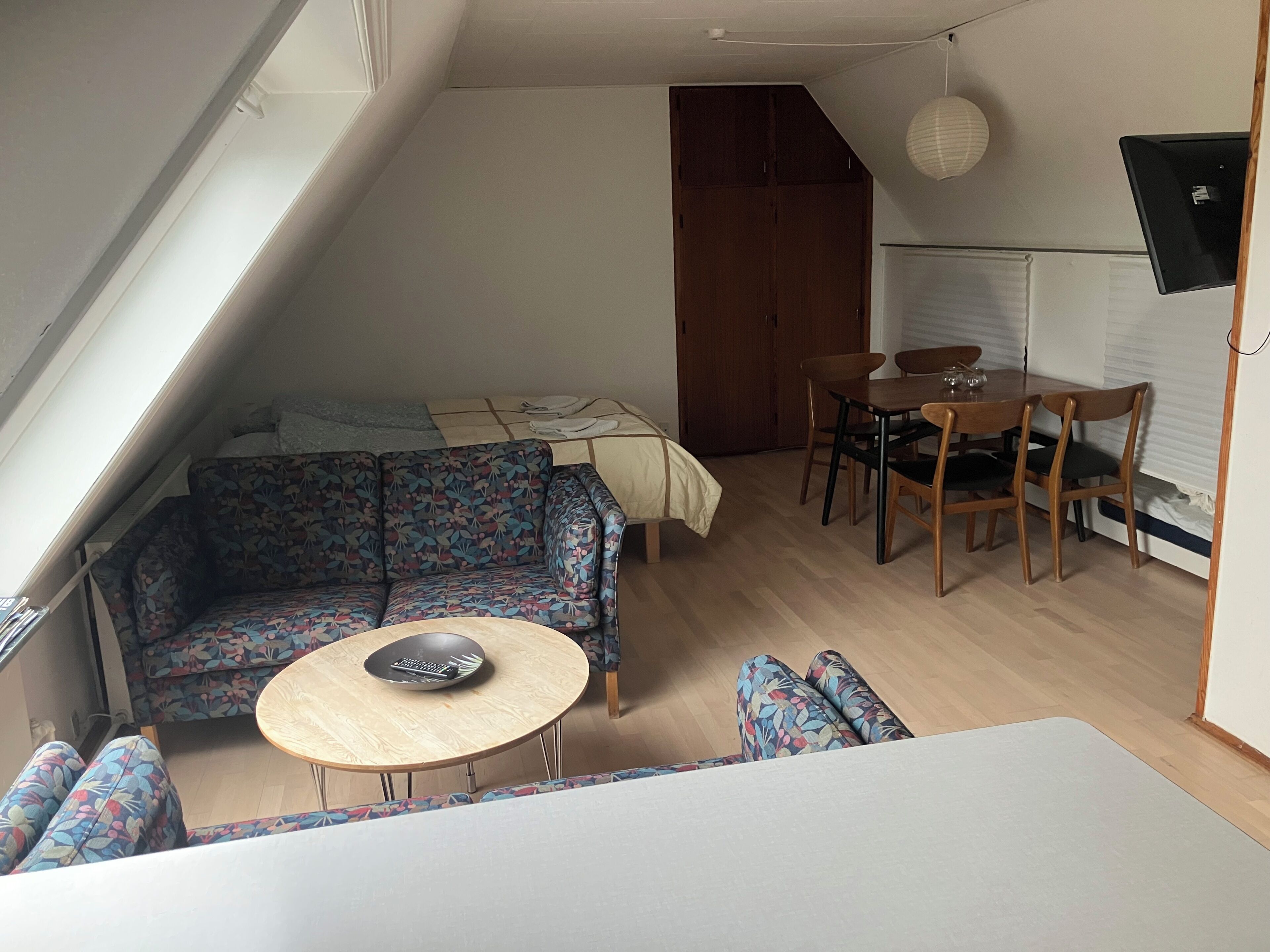 A compact living space with a sofa, a dining table, and a small round table.
