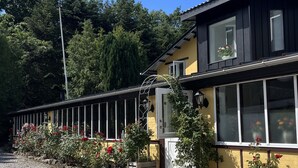 A building with a yellow facade, large windows, and a gravel driveway. - Danninghus (Svendborg)