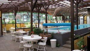 An indoor pool area with multiple seating arrangements and a pool. - Danninghus (Svendborg)