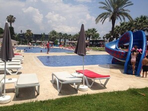 Een seizoensgebonden buitenzwembad, parasols voor strand/zwembad
