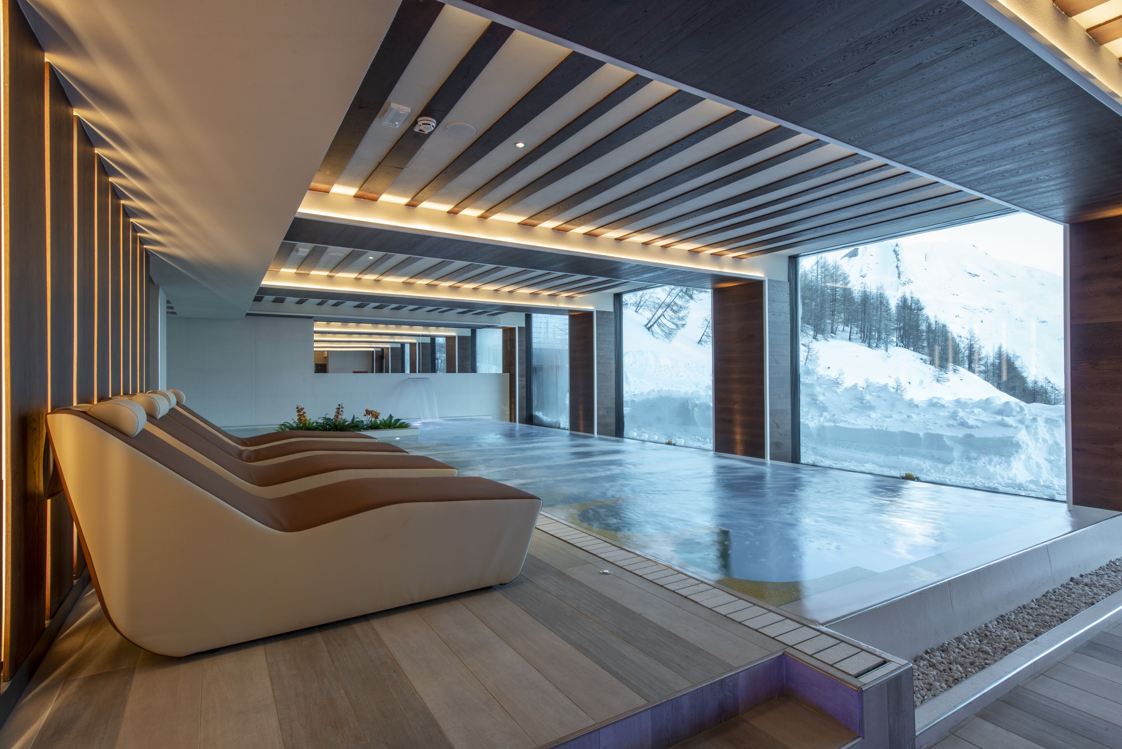 Una piscina techada, sillones reclinables de piscina