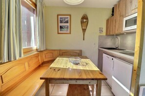 A compact kitchen with wooden cabinetry, a built-in microwave, and a sink.