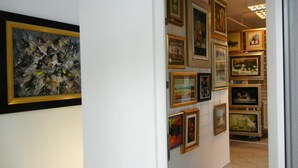 Een gang met diverse kunstwerken in lijsten aan de wanden.