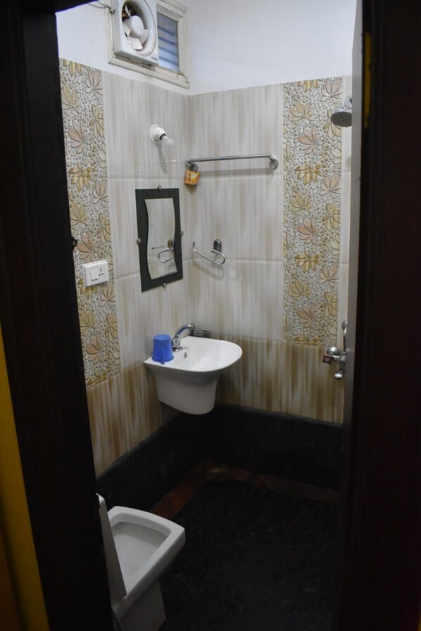 Un baño pequeño con lavabo, espejo y ducha.