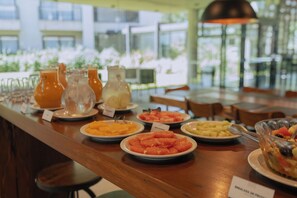 A breakfast buffet with various fruits and beverages.