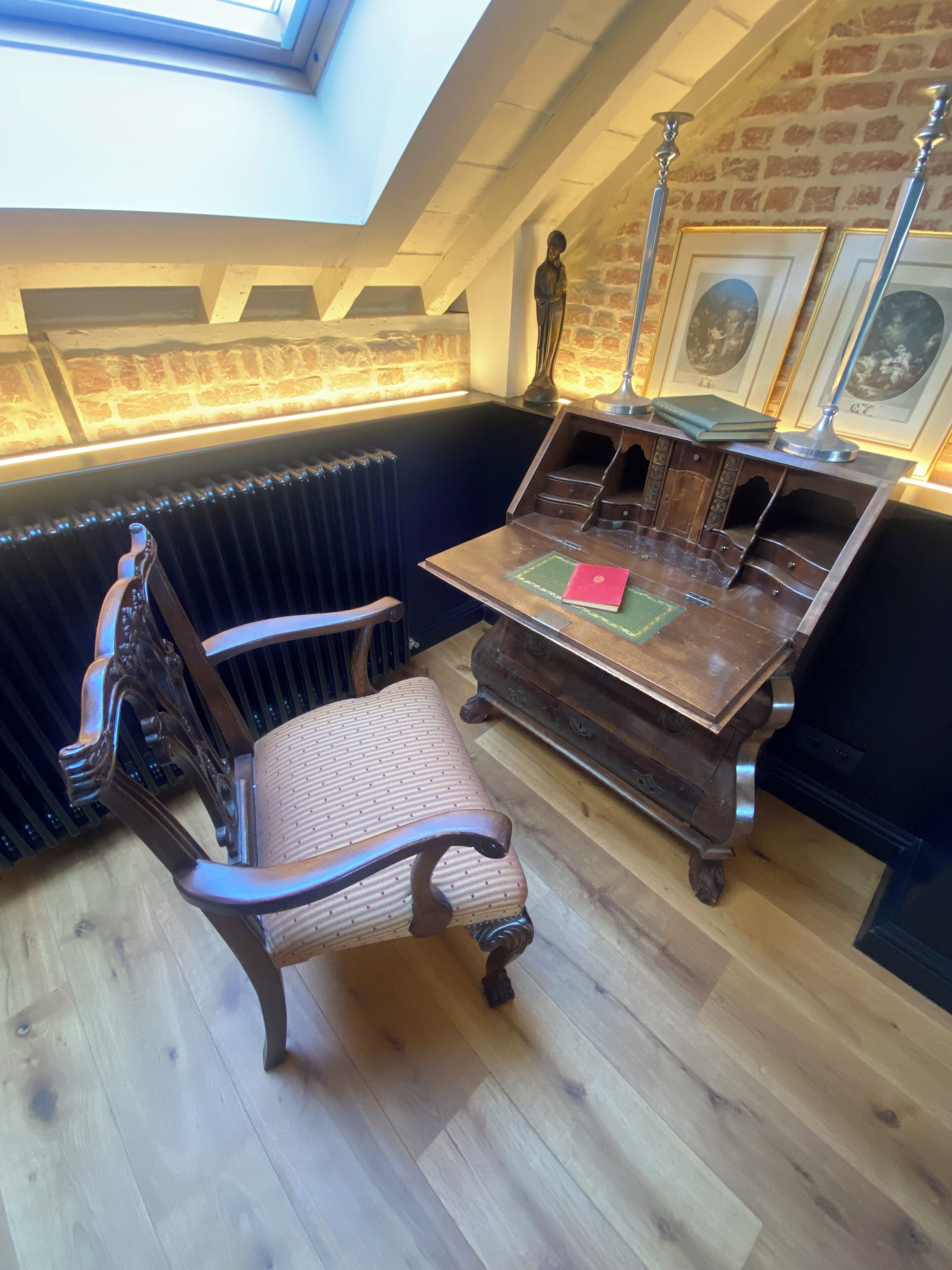 Een werkkamer met een houten bureau, stoel en boeken.