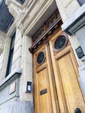 A large wooden double door with intricate carvings and a metal plaque. - B&B Au Lit Jerome (Antwerp)