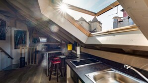 Una cocina moderna con tragaluz, suelo de madera y vistas a edificios.