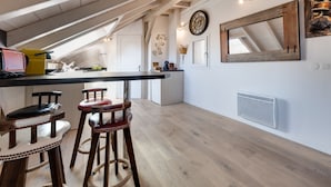 Una cocina moderna con techo de madera, una isla central y taburetes de bar.