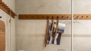 Ein Zimmer mit einem Holzanzughalter, einem runden Tisch und zwei Stühlen.