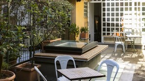 Eine Terrasse im Freien mit Whirlpool, Sitzgelegenheit und Blumentöpfen.