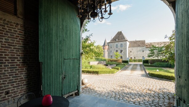 A covered outdoor area with a cobblestone path leading to a historic building. - Magnificent Character Cottage with Spa Tub near Marche-en-Famenne (Marche-en-Famenne)