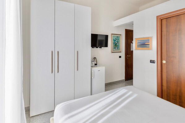 A bedroom with a bed, a wardrobe, a television, and a door. - Aiello Suites Milan (Milan)