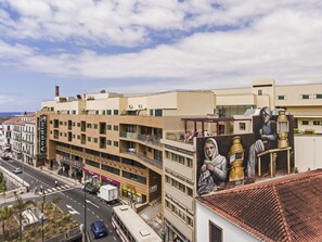 A multi-story building with a modern architectural style, featuring balconies and large windows.