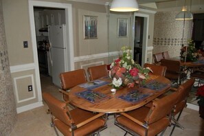 A dining room with a wooden table, brown leather chairs, and a vase of flowers. - Luxury Condo in Spectacular Sugar Mountain North Carolina (Sugar Mountain)