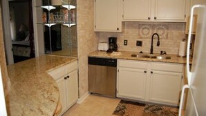 A kitchen with white cabinets, a dishwasher, a coffee maker, and a sink. - Luxury Condo  in Spectacular  Sugar Mountain  North Carolina (Sugar Mountain)