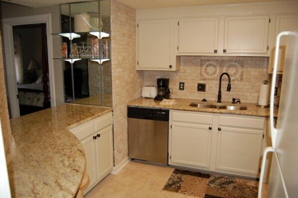 A kitchen with white cabinets, a dishwasher, a coffee maker, and a sink. - Luxury Condo in Spectacular Sugar Mountain North Carolina (Sugar Mountain)