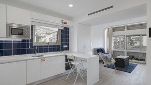 Une cuisine moderne équipée d’un four à micro-ondes, d’un évier et d’une fenêtre donnant sur un paysage urbain.