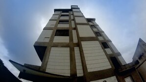 A tall building with a grid-like facade and large windows. - Hotel Harmonia (Praia Grande)