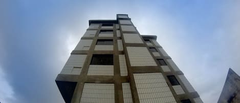 A tall building with a grid-like facade and large windows.