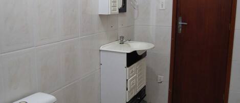 A small bathroom with a toilet, a sink, and a cabinet.