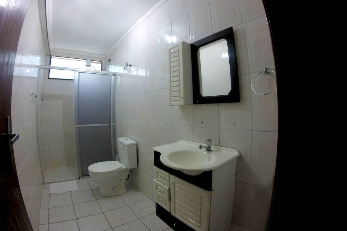 Une salle de bain avec des toilettes, un lavabo et un miroir.
