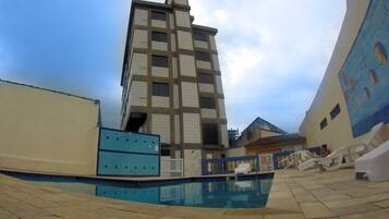 Un área de piscina con un edificio alto al fondo.