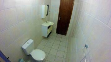 A small bathroom with a toilet, sink, and shower.