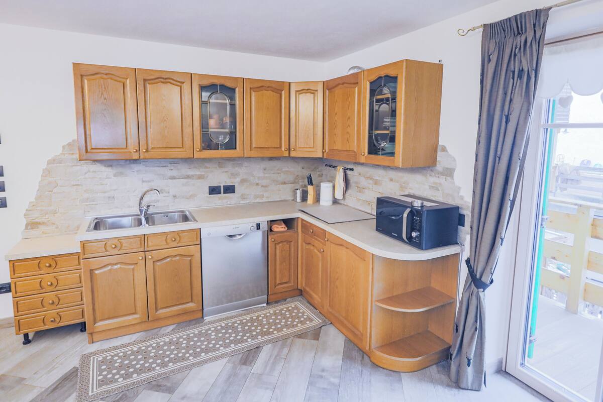 A modern kitchen with wooden cabinets, a dishwasher, and a microwave.