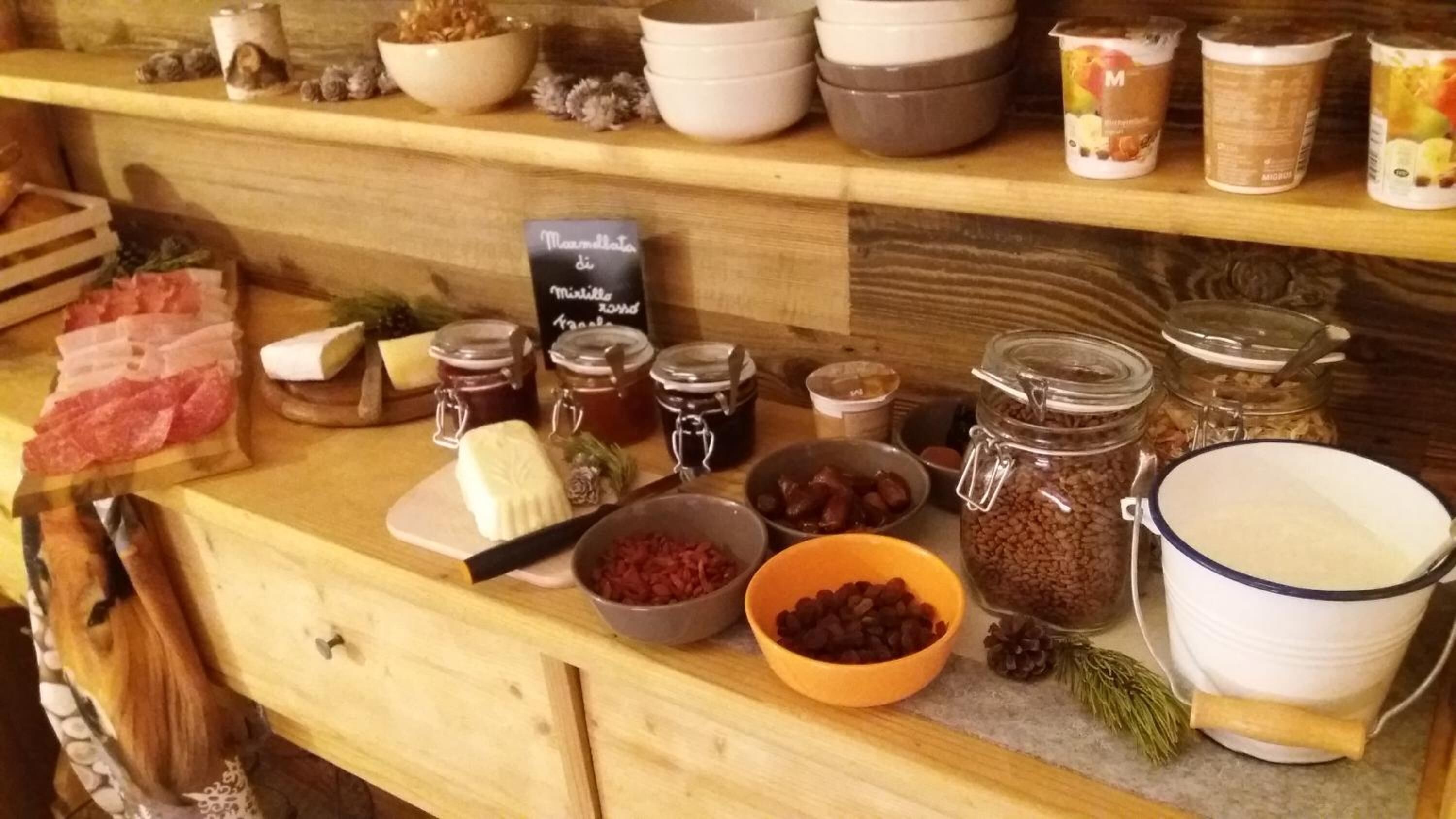 Eine Holztischplatte mit verschiedenen Lebensmitteln, Gläsern und Behältern.