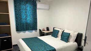 A hotel room with a bed, a desk, a chair, and a wardrobe. - Hotel de la Paix Lyon Sud Givors (Givors)