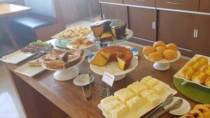 A buffet table with various desserts including cakes, pastries, and bread. - Paracambi Top Hotel (Paracambi)