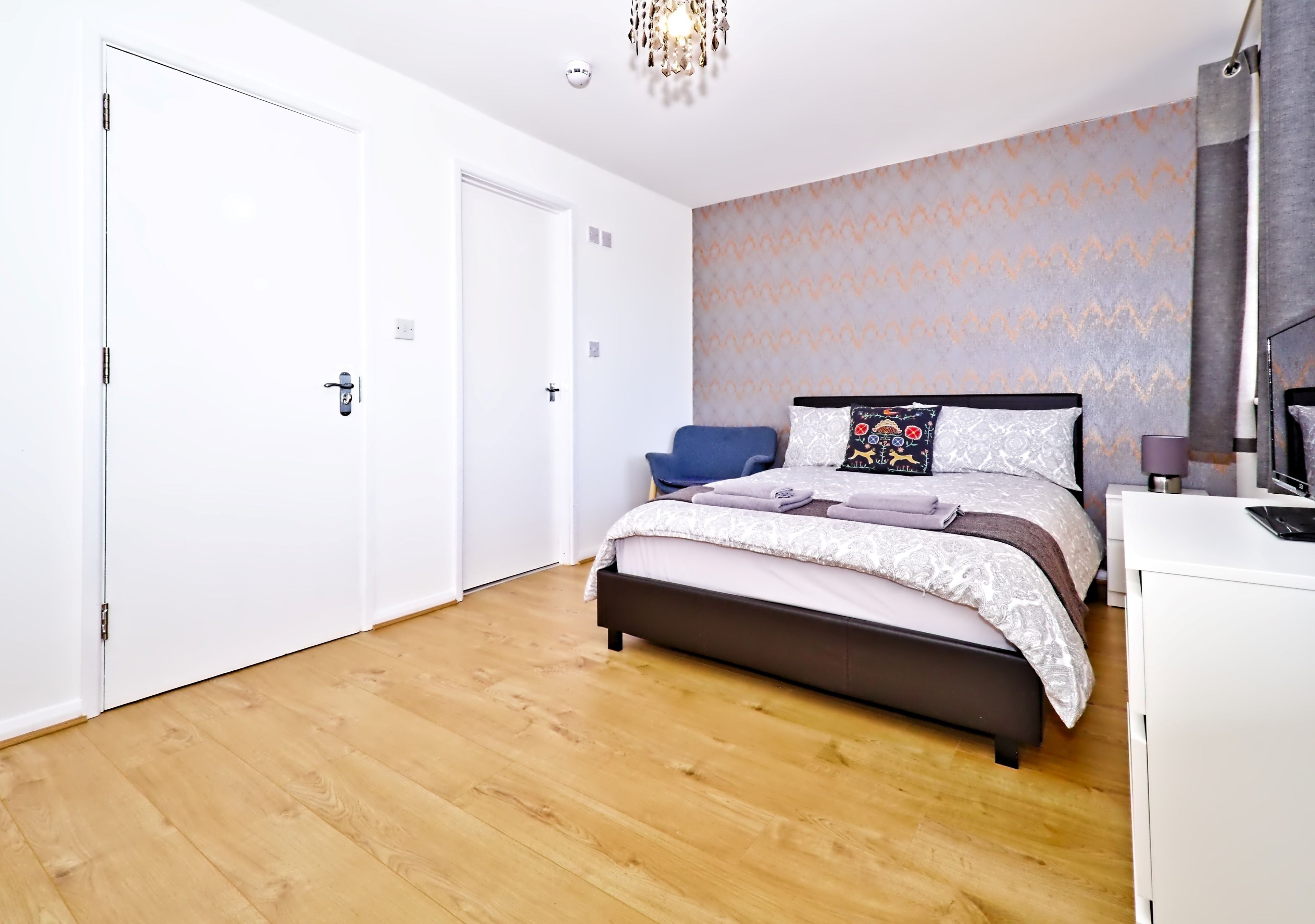 Une chambre à coucher avec un lit, un bureau, une chaise et une armoire.