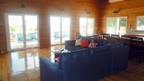 Ein Holzblockhaus-Interieur mit einem blauen Sofa, einem Esstisch und Stühlen.