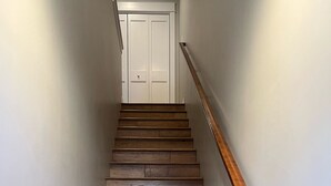 A wooden staircase with a wooden handrail leading to a white door at the top. - Beautiful New Luxury Condo in Downtown Salida! #0676 (Salida)