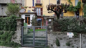 Un edificio amarillo con fachada de piedra, una reja de metal y un letrero que indica acceso privado.